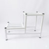 PS02MT0014a Two-tier white galvanised steel plant stand with slatted platforms and protective foot caps. Rust-resistant, powder-coated finish creates a stylish stepped display for indoor or outdoor greenery.